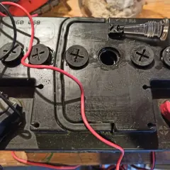 Uszkodzona cela w akumulatorze objawy: widać wyciek elektrolitu i uszkodzoną pokrywę.