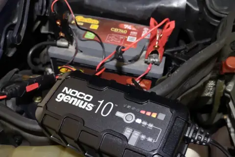 Ładowanie akumulatora na mrozie. Urządzenie NOCO Genius 10 podłączone do akumulatora samochodowego, by zapewnić mu energię w niskich temperaturach.