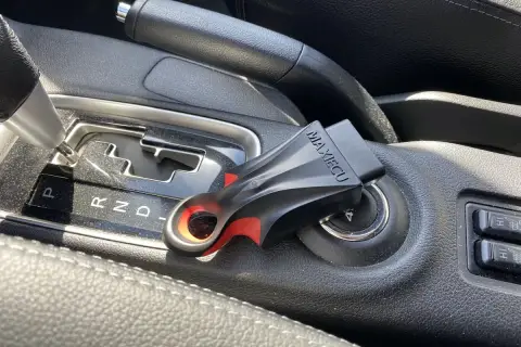 Interfejs diagnostyczny Citroen MAXIECU wpięty w gniazdo zapłonu, obok dźwigni zmiany biegów.