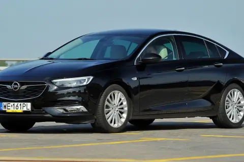 Czarny Opel Insignia na parkingu. Zastanawiasz się, jaki najlepszy silnik wybrać do tego modelu?