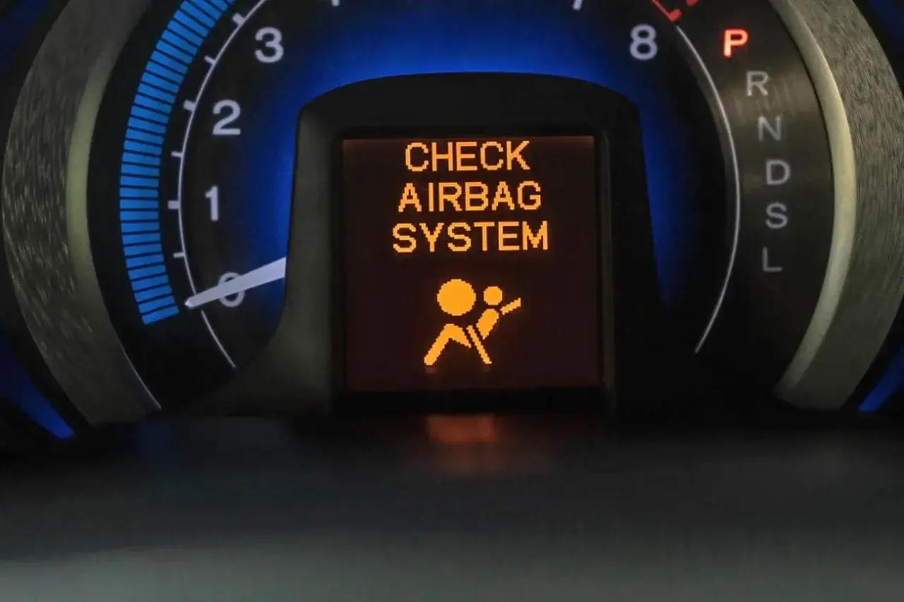 Na desce rozdzielczej świeci się komunikat "CHECK AIRBAG SYSTEM" i symbol poduszki powietrznej. To oznacza, że wystąpił błąd systemu airbag.